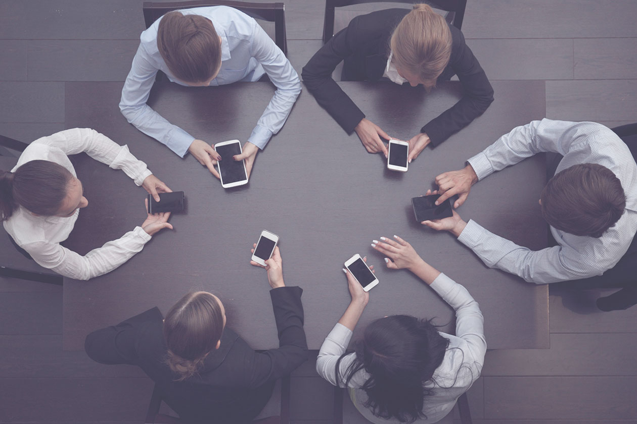 A table of business owners with phones trying to explain It management in Australia